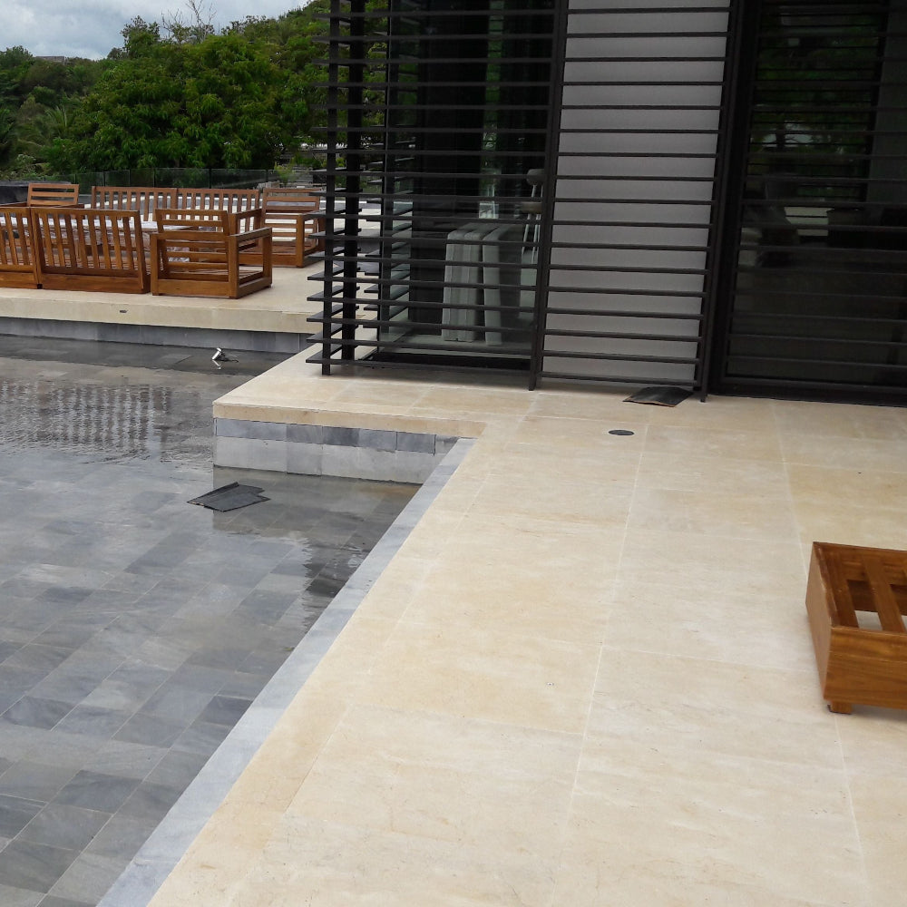 Outdoor patio area with pool, wooden furniture, and greenery