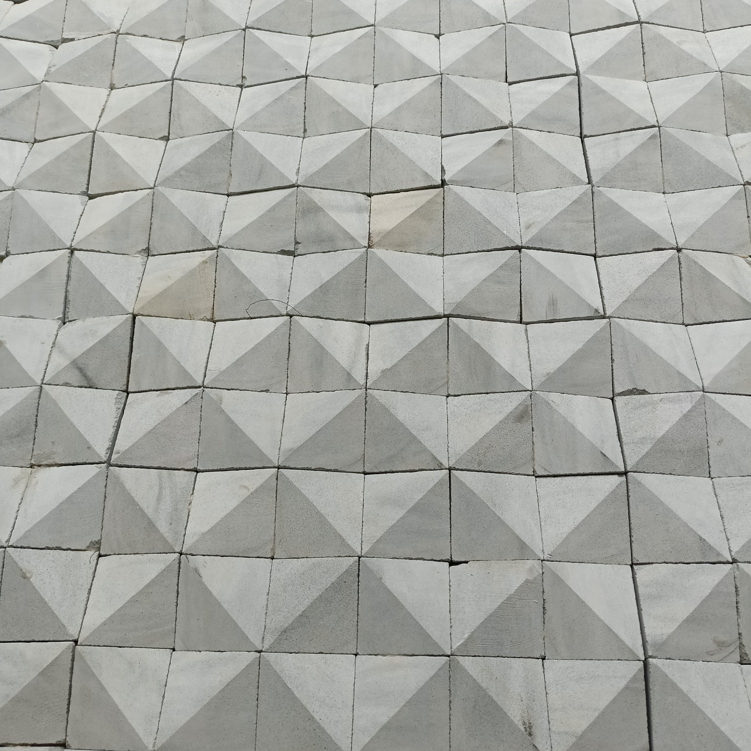 Geometric pattern of gray Zeolite tiles arranged in a diamond formation.
