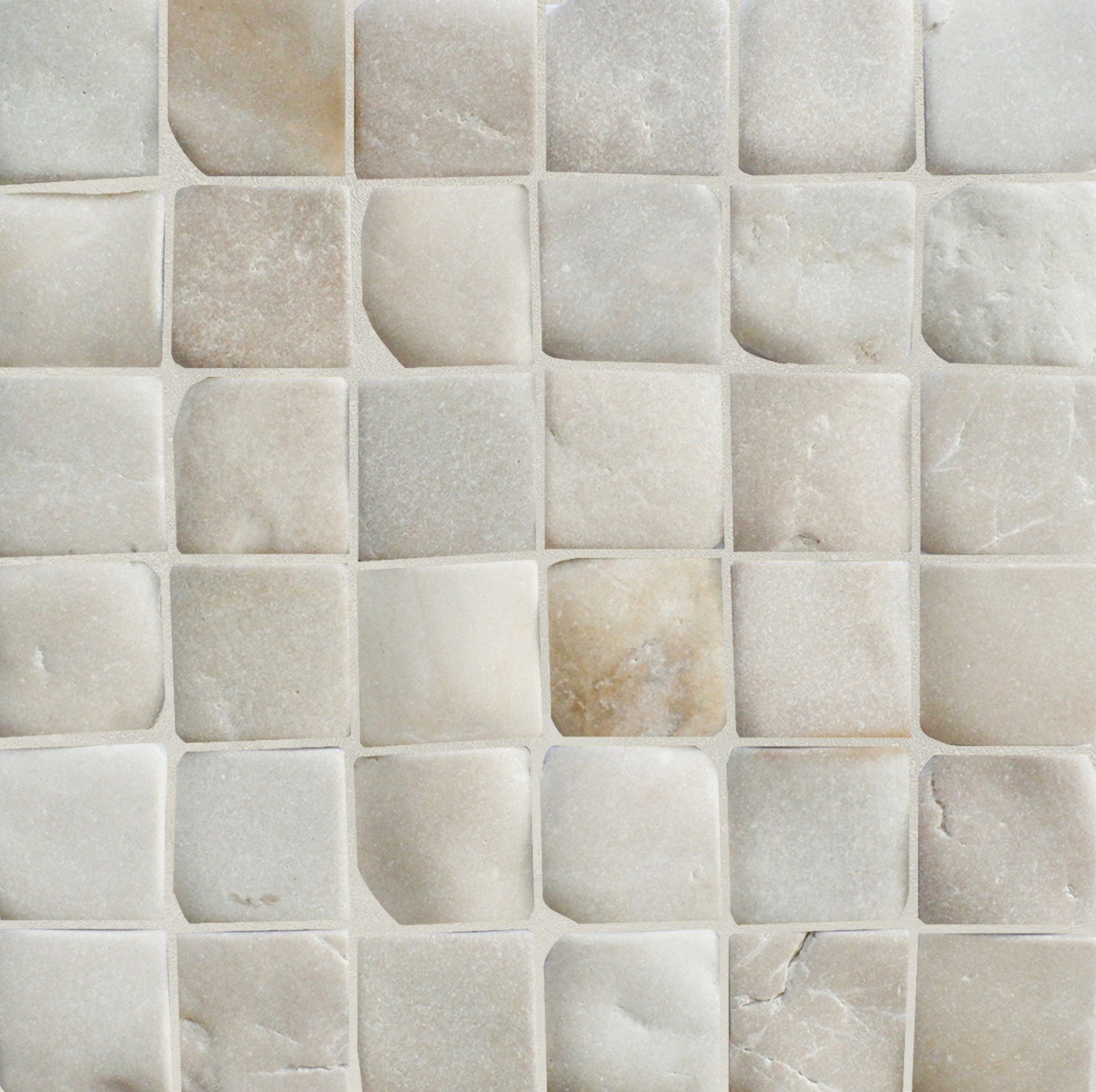 Close-up of a tiled wall with square pebble mosaic tiles in beige.